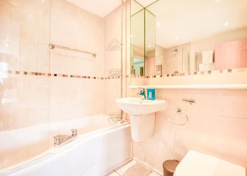 a bathroom with a sink and a toilet and a tub at Austin David Apartments - Hendon Pad in Hendon