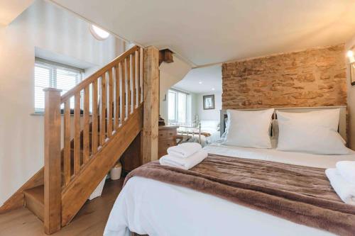 a bedroom with a large bed and a staircase at The Forge, Pillar Box Farm Cottages in Ludlow