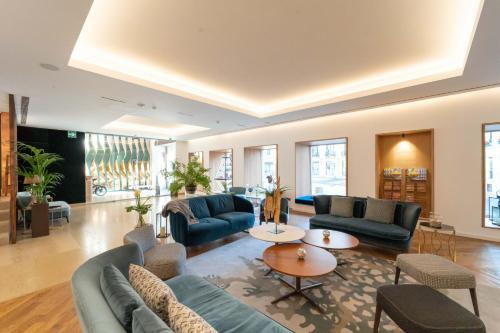 a living room with blue couches and a table at Lasala Plaza Hotel - Adults Only in Donostia-San Sebastián