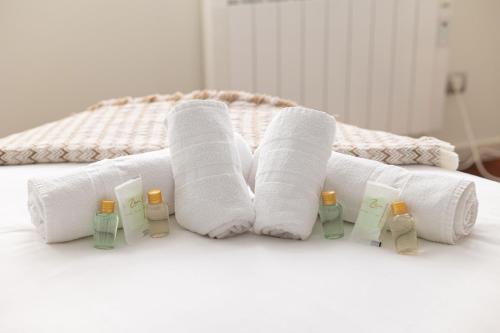 een groep handdoeken en flessen op een bed bij IZARO BEST VIEW By Urdaibai Rentals in Bermeo