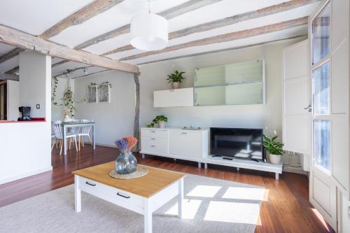 a living room with a table and a tv at IZARO Best View in Bermeo