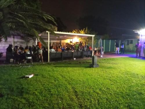 een groep mensen die 's nachts in een park zitten bij Munach Guest Lodge in Benoni