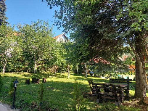 een park met banken en een boom in het gras bij Šarm 402 in Zlatibor