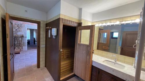 uma casa de banho com um lavatório e um espelho grande em AMAZING Typical House with Swimming Pool em Sant Feliu de Guixols