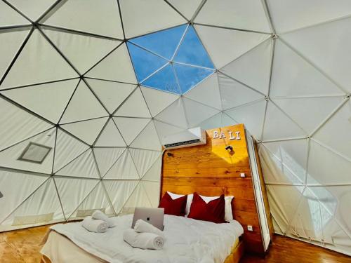 Zimmer mit einem Bett in einer dreieckigen Wand in der Unterkunft Bali Glamping in Ambrolauri
