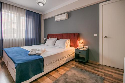 a bedroom with a large bed with a blue blanket at MARİA House in Antalya