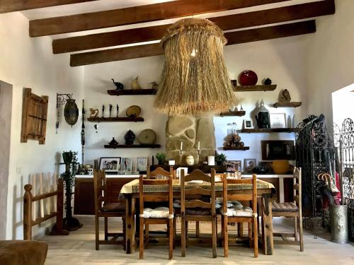 a dining room with a table and chairs and a chandelier at Chalet La Ahumada - Piscina y golf in Tarifa