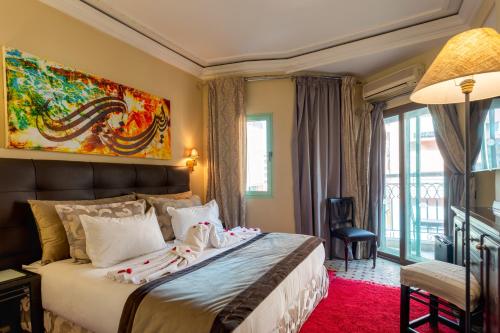 a bedroom with a large bed with a painting on the wall at Le Caspien Boutique Hotel in Marrakesh