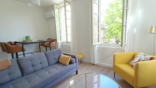 a living room with a blue couch and yellow chairs at Dastro Logis in Saint-Rémy-de-Provence