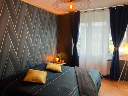 een slaapkamer met een blauw bed met 2 kussens erop bij Maison des Sens in Saint-Omer