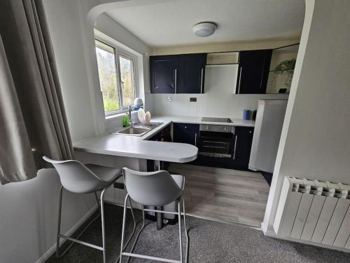 een kleine keuken met een tafel en stoelen. bij Entire Spacious Modern One Bedroom House in Swindon