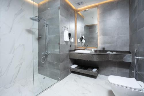 a bathroom with a shower and a sink and a toilet at AKASIYA HOTEL in Doha