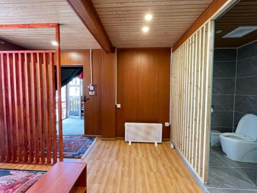 Habitación con paredes de madera y baño con aseo. en Timeless Inn, en Shangri-La