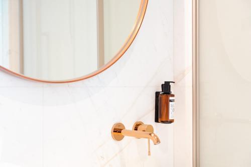 a bathroom with a mirror and a soap dispenser at Lasala Plaza Hotel - Adults Only in Donostia-San Sebastián