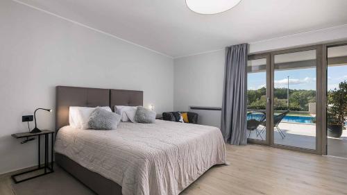 ein Schlafzimmer mit einem großen Bett und einem Pool in der Unterkunft A stunning villa with a swimming pool in Lindar near Pazin in Lindar