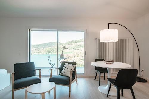 a living room with a table and chairs at La Palma 1 by Quokka 360 - modern panoramic lake view flat in Montagnola