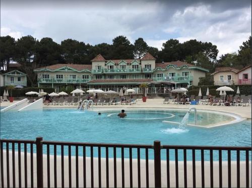 duży basen z ludźmi w wodzie w obiekcie Maison NAUCALA proche de la piscine w mieście Lacanau