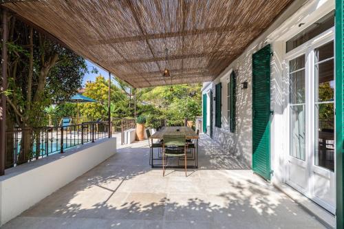 d'une terrasse avec une table et des chaises sur le côté du bâtiment. dans l'établissement Luxurious Villa with heated pool 5BR-10p - Cannes, à Cannes