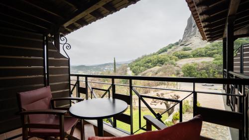 a balcony with a table and chairs and a view at Dellas Boutique Hotel in Kalabaka