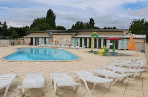 una piscina con sillas blancas y un parque infantil en Mobil-home tout confort climatisé 6 personnes proche Europa Park, route des vins, Alsace en Boofzheim