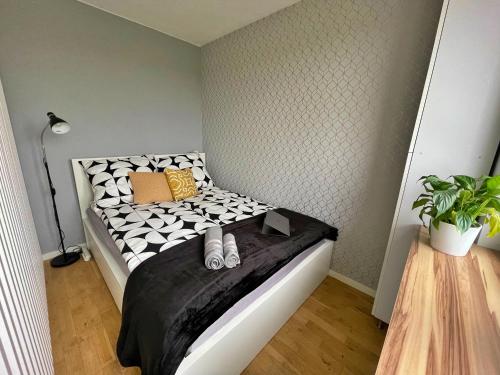 ein kleines Schlafzimmer mit einem schwarzen und weißen Bett in der Unterkunft Szucha 27 - Royal Łazienki Flat in Warschau
