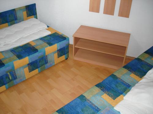 a bedroom with two beds and a wooden floor at Seaside Cottage Bor in Gdinj