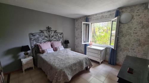 Un dormitorio con una cama con almohadas rosas y una ventana en GÎTE Romantic Room, en Le Val