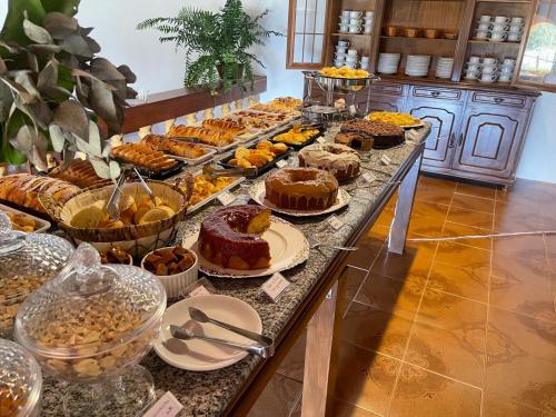 een buffet met verschillende soorten gebak en zoete deegwaren bij Fascinação Café Hotel in Cunha