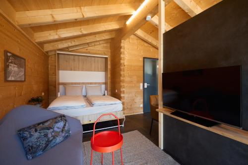 a bedroom with a bed and a flat screen tv at Achners Chalet am Forsthaus in Wallgau