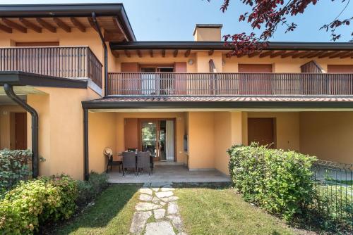 ein Haus mit einem Balkon und einer Terrasse in der Unterkunft Villaggio Tamerici in Lignano Sabbiadoro