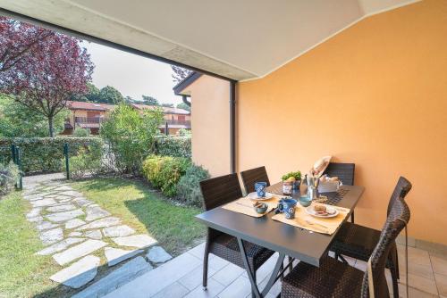 einen Esstisch und Stühle auf einer Terrasse in der Unterkunft Villaggio Tamerici in Lignano Sabbiadoro