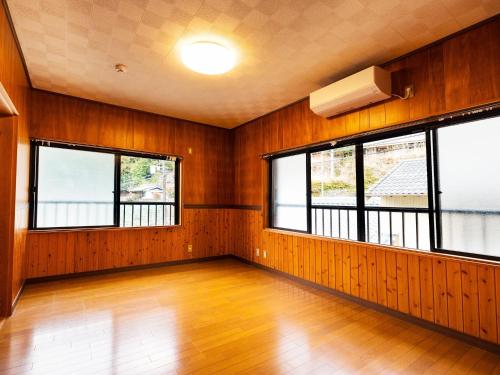 an empty room with wood paneling and windows at Goenza OYADO - Vacation STAY 86977v in Takinohai