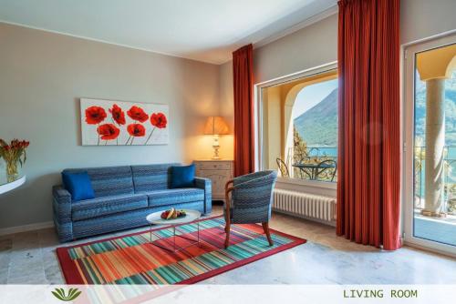 a living room with a blue couch and a window at Dependence del Parco in Porlezza