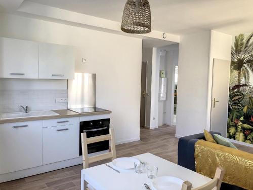 uma cozinha e uma sala de estar com uma mesa em Résidence Appartements Niort wifi-parking em Niort