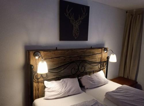 sypialnia z łóżkiem z drewnianym zagłówkiem i światłami w obiekcie Ferienwohnung Hirschkopf im Südschwarzwald w mieście Kleines Wiesental