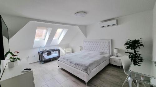 een slaapkamer met een bed en een tv. bij Bécsi Kapu Apartman in Vác