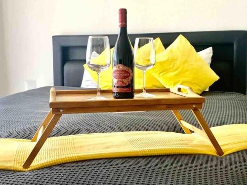 a wooden table with two glasses and a bottle of wine at Little Penthouse **** in Dietikon