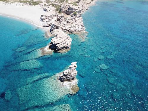 a group of rocks in the water next to a beach at Blue Stone in Triopetra