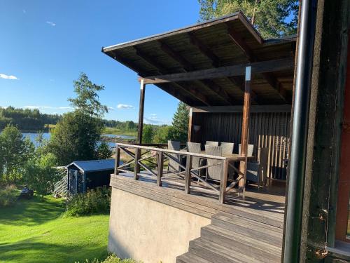 a wooden deck with a table and chairs on it at The paradise by the beach in Långviken