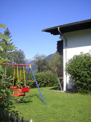 a swing in a yard next to a house at Tyrol Appartements in Ehrwald