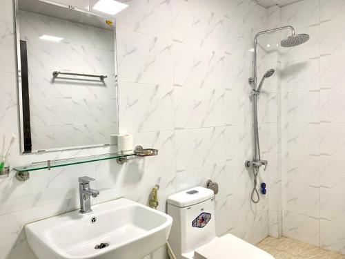 Hotel trung hiếu في ها لونغ: حمام أبيض مع حوض ومرحاض