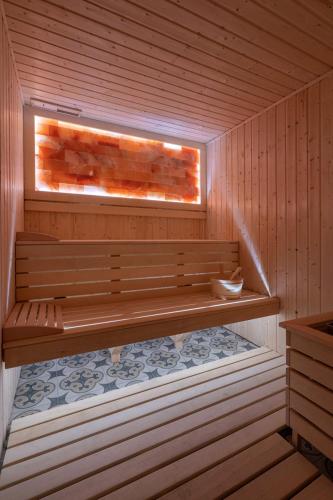 a wooden sauna with a bench and a window at Małopolanka & Spa in Krynica Zdrój