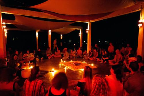 un grupo de personas sentadas alrededor de un escenario con velas en Atlas Valley en Pai