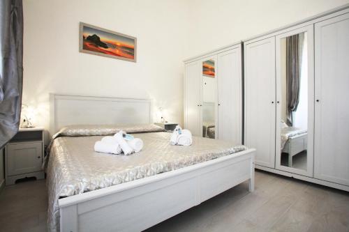 a white bedroom with two towels on a bed at Brillante Appartamento di Sara -Daniele Case Vacanza in Anzio