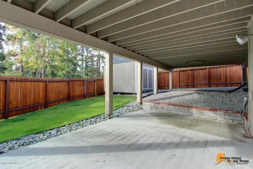 an empty patio with a fence and grass at Alaskan Sunset House - Ground Floor Unit in Anchorage