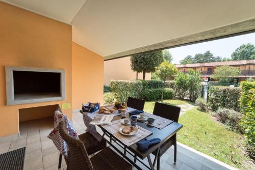 comedor con mesa, sillas y TV en Villaggio Tamerici, en Lignano Sabbiadoro
