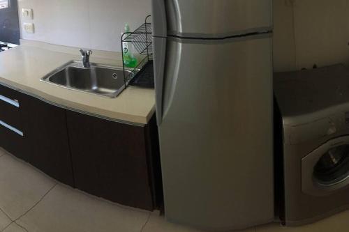 una cocina con refrigerador de acero inoxidable junto a un fregadero en Nice Super confortable flat in the best location, with a great pool! en Buenos Aires