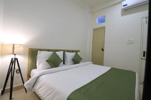 a bedroom with a large bed with a green blanket at Around Stays Rishikesh, Tapovan in Rishīkesh