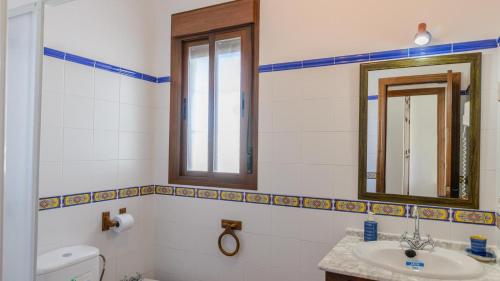 ein Badezimmer mit einem Waschbecken, einem WC und einem Spiegel in der Unterkunft Villanueva - Casa 2 Conil Frontera by Ruralidays in Conil de la Frontera