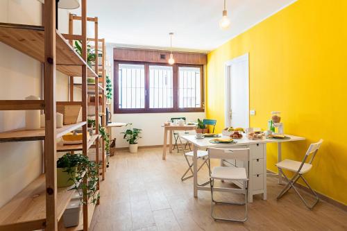 a room with a yellow wall and a table and chairs at Dimora Il Parco in Bologna